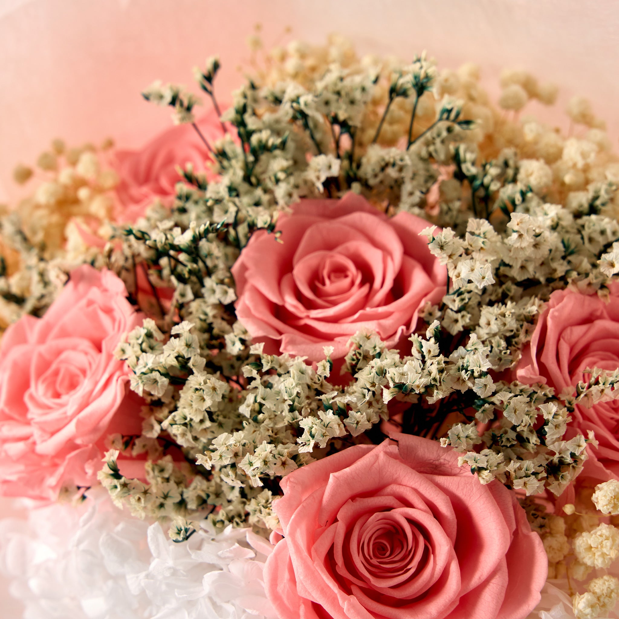 Bouquet of pink roses with greenery on a soft pink background
